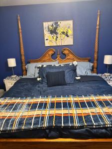 een slaapkamer met een groot bed met een houten hoofdeinde bij The House in Mena