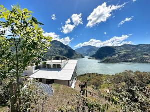a house on a hill next to a river at La Vista EcoHouse in Macanal