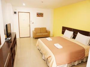 a bedroom with a large bed and a chair at Diamond Bangkok Apartment in Bangkok