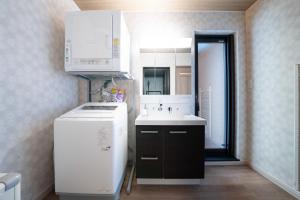 eine kleine Küche mit Spüle und Kühlschrank in der Unterkunft THE Sakura in Kami-furano + 130 Fotos