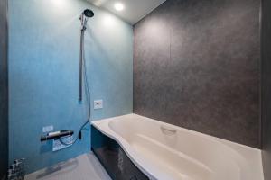 ein Badezimmer mit Badewanne und Dusche in der Unterkunft THE Sakura in Kami-furano
