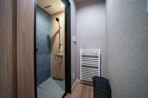 Zimmer mit einem Flur mit Tür und Stuhl in der Unterkunft THE Sakura in Kami-furano