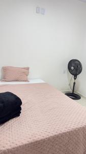 a bed with a pink blanket and a fan at Canto do Mangue in Cascavel +24 photos