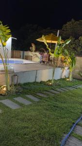 a patio with a table and chairs and an umbrella at Canto do Mangue in Cascavel