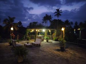 a patio at night with a gazebo and lights at Villa D40 in Weligama