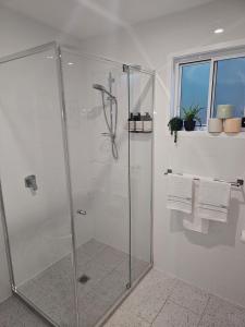a shower stall in a bathroom with white walls at Mayers Cottage in Perwillowen +12 photos