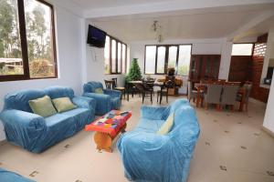 a living room with blue couches and a table at Casa de Campo Apu San Isidro in Urubamba
