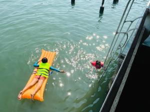 a woman laying on a raft in the water at Happy Fuji Homestay in Ko Phrao Nai