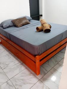 a wooden bed frame with a teddy bear laying on it at La Frontera in Puerto Iguazú