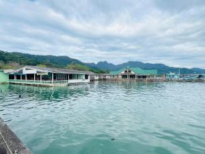 a group of houses on a body of water at Happy Fuji Homestay in Ko Phrao Nai