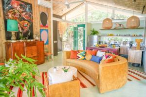 una sala de estar con un sofá y una mesa en Casa Aguaspoolyoga Deckwalk To Surf Point, en Santa Teresa Beach