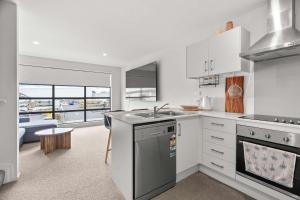 a kitchen with a sink and a stove top oven at Coastal Bliss in Mount Maunganui