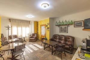 a living room with leather furniture and a table at HOSPEDAJE MARISA in La Hermida