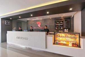un ristorante con persone in piedi dietro un bancone con un frigorifero di Red Planet Makati Amorsolo a Manila
