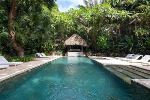 a swimming pool in a resort with chairs and trees at Nest Bungalow - Pool Walking To The Beach in Santa Teresa Beach