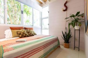 a bedroom with a bed and a potted plant at Nest Bungalow - Pool Walking To The Beach in Santa Teresa Beach +29 photos