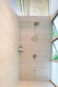 a bathroom with a shower with wooden walls at Bungalow in Santa Teresa Beach