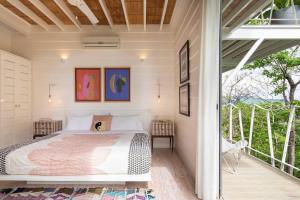 Un dormitorio con una cama en un balcón. en Casazul - Tropical Escape Ocean Views, en Santa Teresa Beach