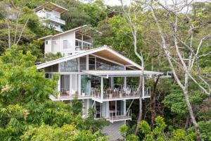 una casa en la cima de una colina con árboles en Casazul - Tropical Escape Ocean Views, en Santa Teresa Beach