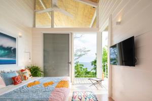 Un dormitorio con una cama y una puerta corrediza de vidrio. en Casazul - Tropical Escape Ocean Views, en Santa Teresa Beach