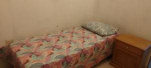 un dormitorio con una cama con almohada y una cómoda en Aloha, en Río Gallegos