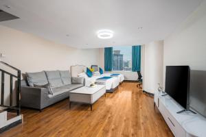 un soggiorno con un divano e una TV di Guangzhou Youke Serviced Apartment1min to Line5 Taojin STN-Free shuttle bus during the Canton Fair a Canton