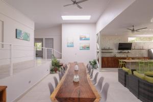 Una sala de estar con una mesa y sillas de madera. en Luxury Beachfront Villabest Surf Spot, en Santa Teresa Beach
