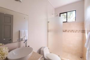 Un baño blanco con lavabo y ducha. en Luxury Beachfront Villabest Surf Spot, en Santa Teresa Beach 39 fotos más
