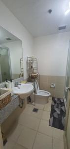 a bathroom with two sinks and a toilet and a mirror at Modern and Cozy 2-Bedroom Condo in Prime Location in Manila