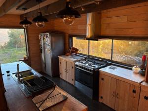 a kitchen with a stove and a refrigerator at La madriguera Matanzas in Navidad