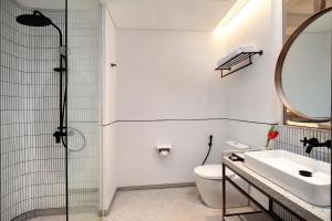 a bathroom with a shower and a sink and a toilet at Hotel Aruss Semarang in Semarang
