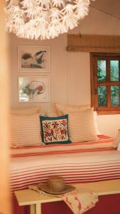 a bedroom with a bed with a hat on a table at Surf Casitas - High Tide Bungalow in Santa Teresa Beach
