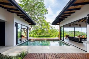 a swimming pool in the backyard of a house at Villa Ayla - Santa Teresa Minutes From The Beach in Carmen