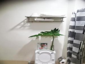 a bathroom with a toilet and a plant on the wall at Cozy Condo in Iloilo City at SMDC Style Residences, Building A, 16th floor, SM CITY ILOILO in Iloilo City +23 photos