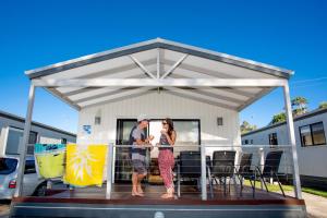 a man and woman standing on a deck under a pavilion at Discovery Parks - Geelong in Geelong