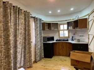a kitchen with curtains in the middle of a room at Citronella Mountain Cottage Nanyuki in Nanyuki