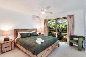 曼斯菲尔德The Link Mansfield - Sleeps 11的一间卧室配有一张带绿色棉被的床和窗户。 更多14张照片