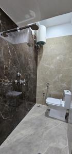 a bathroom with a toilet and a stone wall at Kashi Om Vilas Homestay in Varanasi