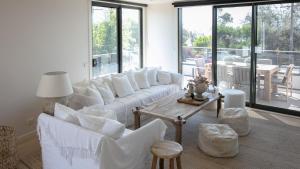 Una sala de estar con sofás blancos y una mesa. en Beach Views, en Dromana