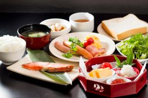 a table with plates of food and bowls of food at APA Hotel Mito-Ekimae in Mito