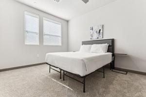 a bedroom with a large white bed with a window at Cozysuites PHX RORO Gym Pool Pets Parking #18 in Phoenix