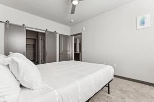 a white bedroom with a large white bed at Cozysuites PHX RORO Gym Pool Pets Parking #18 in Phoenix