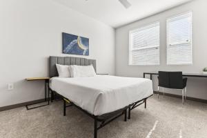 a bedroom with a bed and a desk and a window at Cozysuites PHX RORO Gym Pool Pets Parking #18 in Phoenix +29 photos