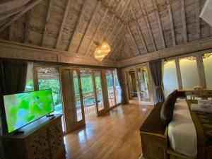 ウブドにあるAbimartha Villa Ubudの薄型テレビとソファのあるリビングルーム