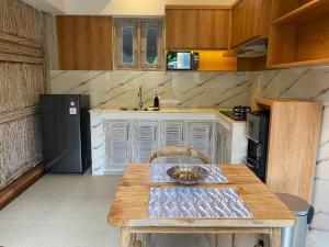 ウブドにあるAbimartha Villa Ubudのキッチン(木製テーブル、黒い冷蔵庫付)