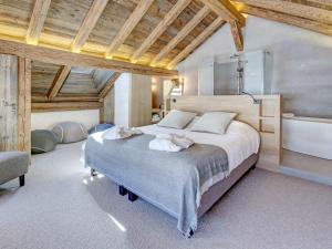 une chambre avec un grand lit et une baignoire dans l'établissement Chalet 5★, 15 pers, 7 chambres, piscine, proche pistes à La Clusaz - FR-1-304-299, à La Clusaz 19 autres photos