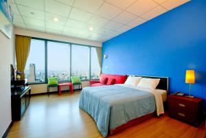 een blauwe slaapkamer met een bed en een blauwe muur bij 空中城都會商旅 in Kaohsiung