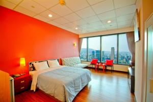 um quarto com uma cama e uma parede vermelha em 空中城都會商旅 em Kaohsiung