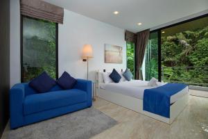 a bedroom with a bed and a blue couch at 4BR Villa B5 with Pool, Vibrant Life at Kata Beach - UTK5 in Kata Beach +36 photos