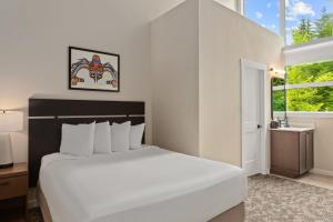 una camera da letto con un grande letto bianco e una finestra di Worldmark Whistler Sundance a Whistler